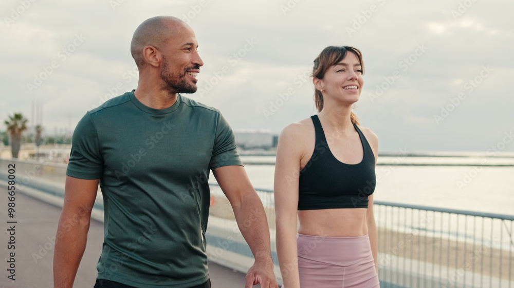 Close-up of an active young sporty couple have dialog, two athletes enjoy conversation and walking Close-up of an active young sporty couple have dialog, two athletes enjoy conversation and walking