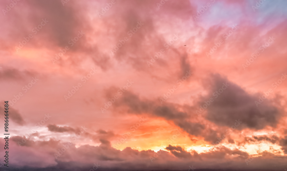 Fototapeta premium A beautiful sky tinted by the sun leaving vibrant shades of gold, pink, blue and multicolored. Clouds in the twilight evening and morning sky. Cloudy sky background in the evening, and during the day.
