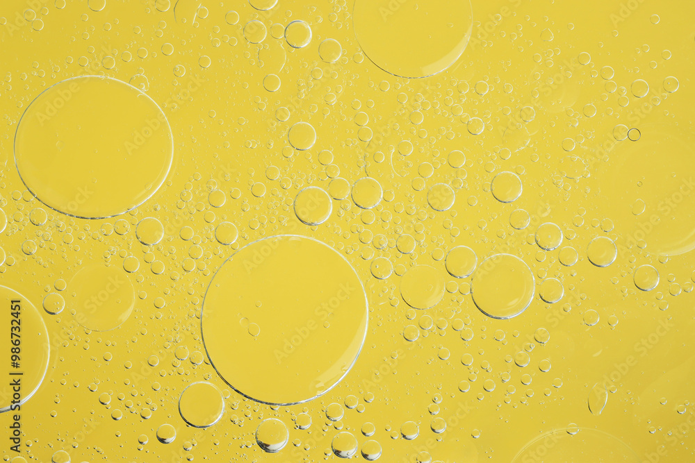 Sample of cosmetic oil on yellow background, macro view Sample of cosmetic oil on yellow background, macro view