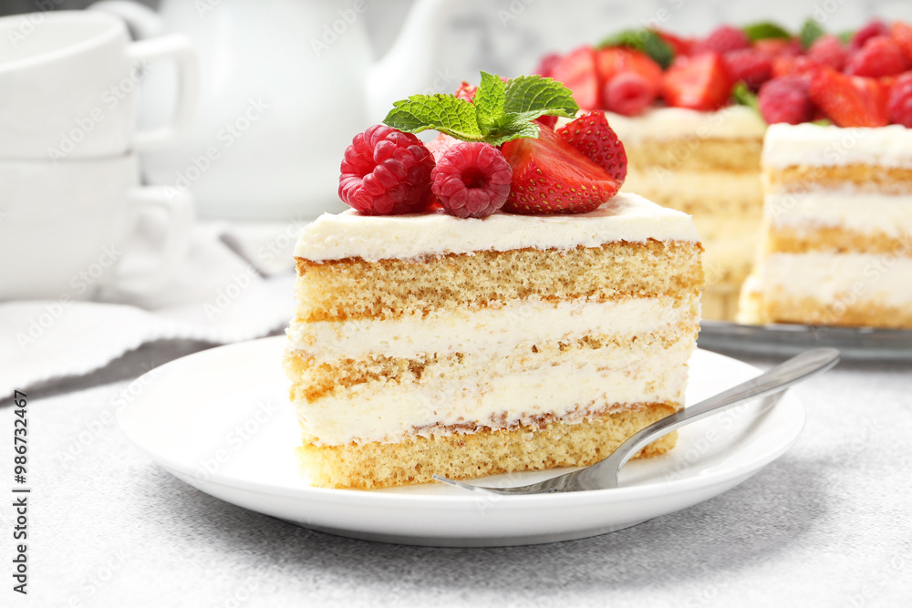 Tasty sponge cake with fresh berries and mint served on light gray table, closeup Tasty sponge cake with fresh berries and mint served on light gray table, closeup