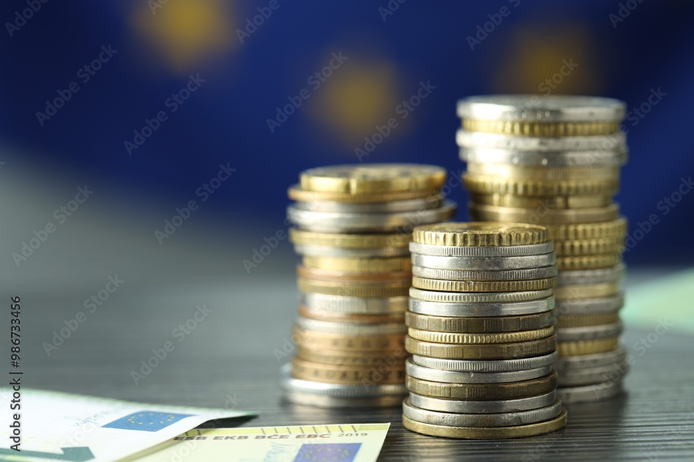 Stacks of coins and euro banknotes on grey textured table, closeup Stacks of coins and euro banknotes on grey textured table, closeup