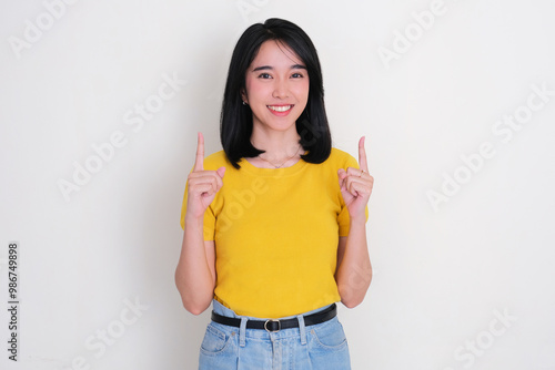 Asian woman smiling at the camera with both hands pointing above her photo