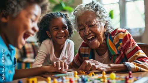 Senior woman laughing joyfully as she wins a board game with her grandchildren