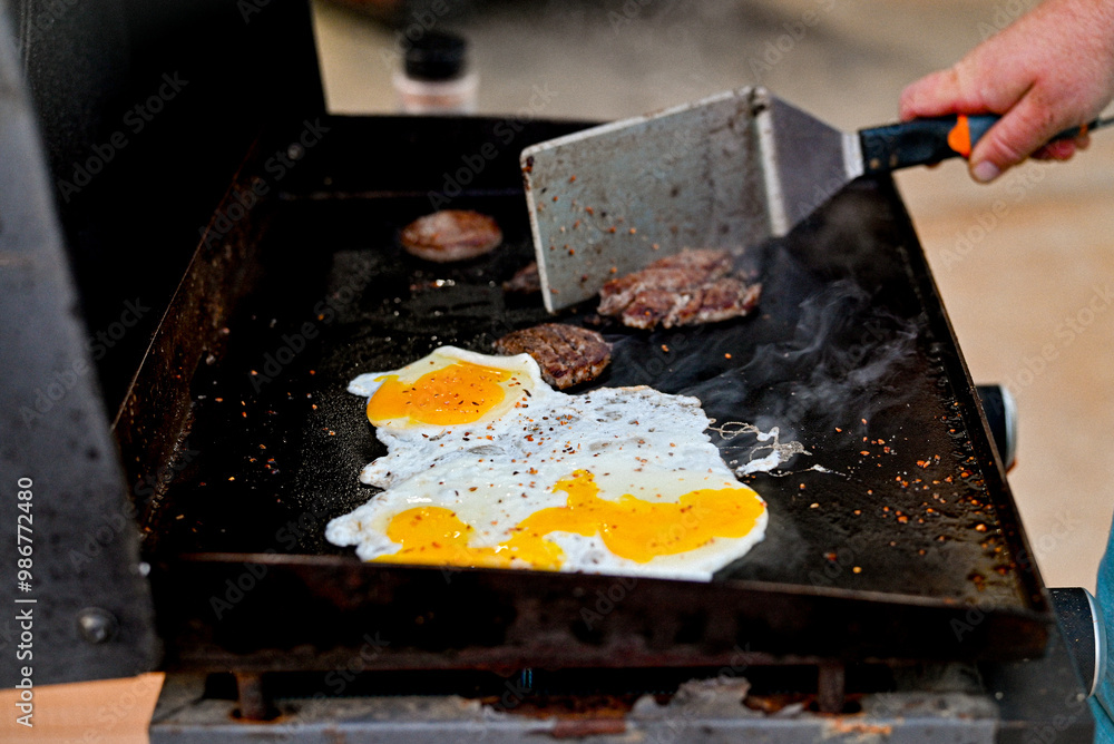 Cooking eggs and sausage on a flat top grill Cooking eggs and sausage on a flat top grill
