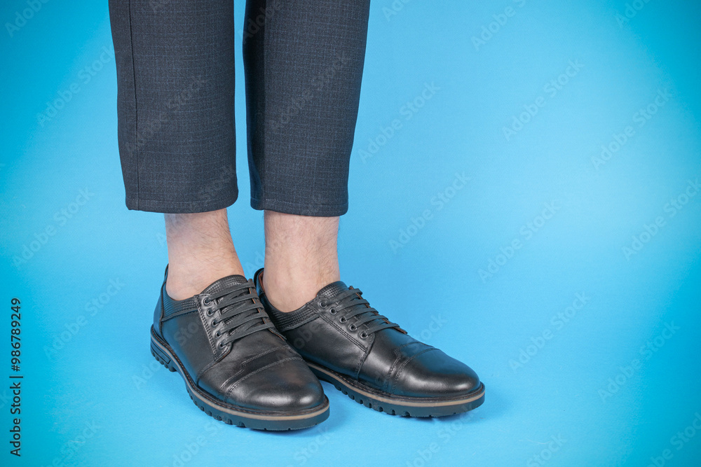 Close-up of Stylish Black Leather Shoes with Business Casual Pants on Blue Background Close-up of Stylish Black Leather Shoes with Business Casual Pants on Blue Background