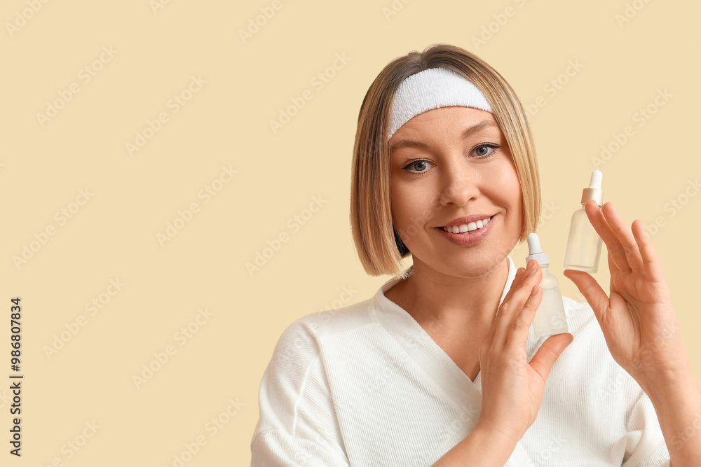 Beautiful mature woman with bottles of essential oil against color background Beautiful mature woman with bottles of essential oil against color background