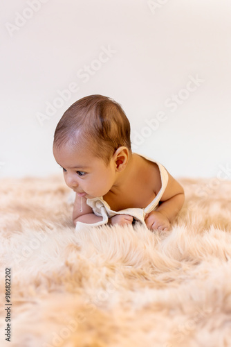 Two-month-old baby boy lying face down on furry rug