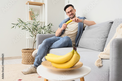 Young man with banana sitti...