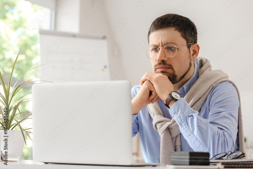 Confused young male teacher with laptop giving online lesson at home Confused young male teacher with laptop giving online lesson at home