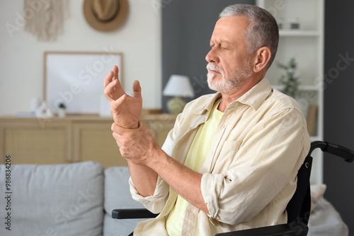 Tablou pe pânză Senior man suffering from Parkinson syndrome in wheelchair at home