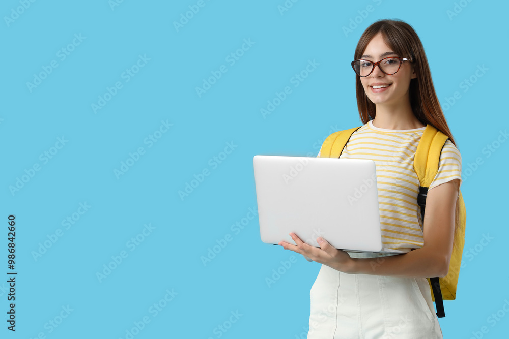 Happy female student with laptop and backpack on blue background Happy female student with laptop and backpack on blue background