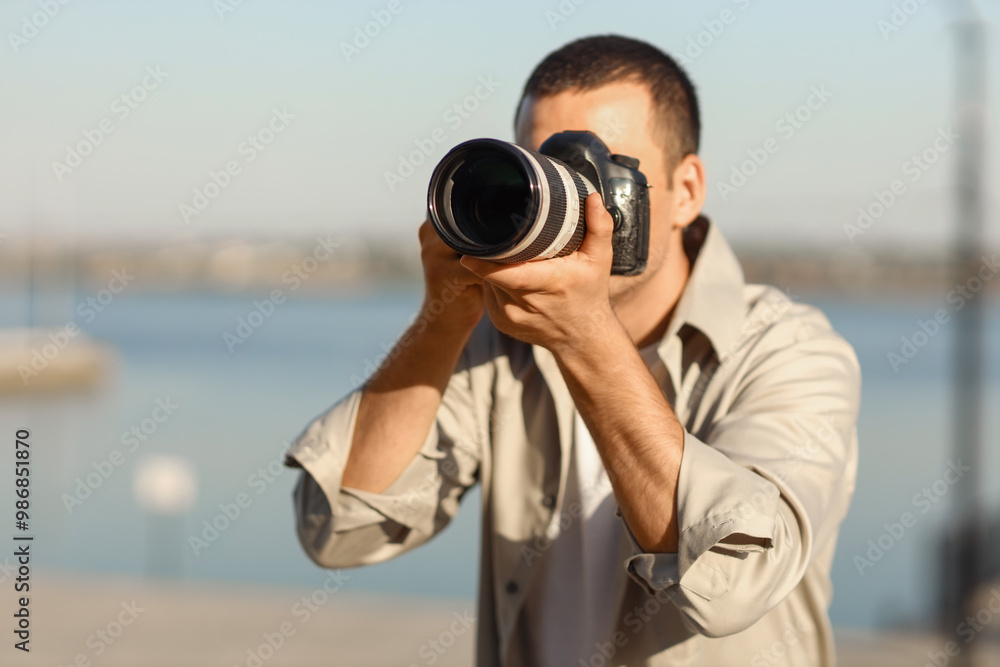 Obraz premium Male photographer with modern camera outdoors