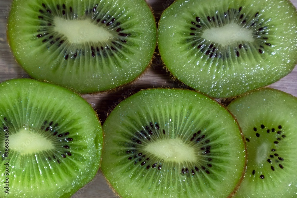 Close-up of fresh Green kiwi slices on a wooden table