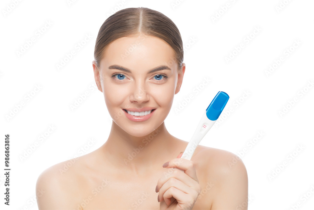 Close-up portrait of young beautiful female, standing with naked shoulders, holding positive pregnancy test Close-up portrait of young beautiful female, standing with naked shoulders, holding positive pregnancy test