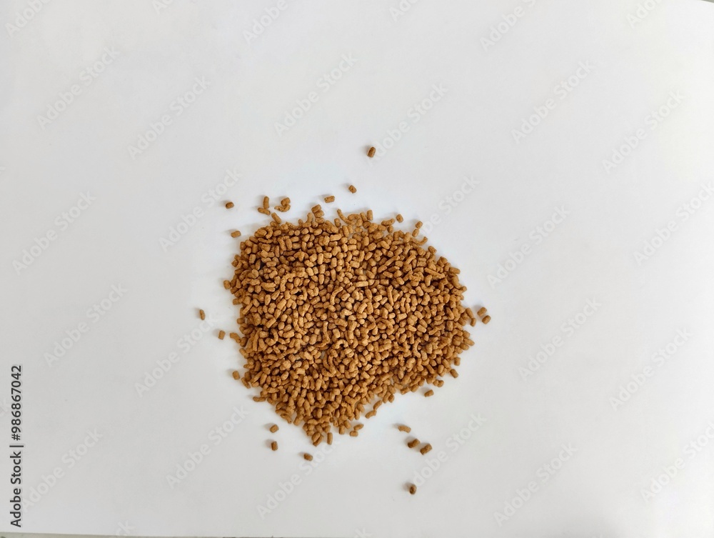 a pile of bright brown turtle pellets on a white background. a pile of bright brown turtle pellets on a white background.