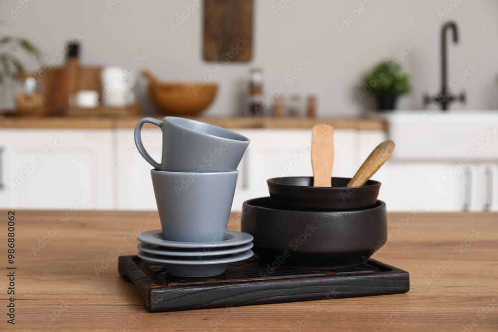 Stacks of bowls, cups and saucers on wooden counter in kitchen Stacks of bowls, cups and saucers on wooden counter in kitchen