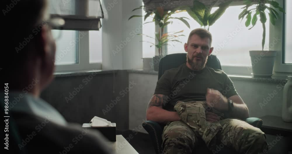 Military man in uniform sits in chair, discusses progress, thanks and shakes hands with psychotherapist after successful therapy or rehabilitation. Professional senior psychologist listens to soldier. Military man in uniform sits in chair, discusses progress, thanks and shakes hands with psychotherapist after successful therapy or rehabilitation. Professional senior psychologist listens to soldier.