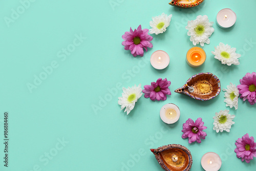 Diya lamps with flowers and candles on turquoise background. Divaly celebration photo