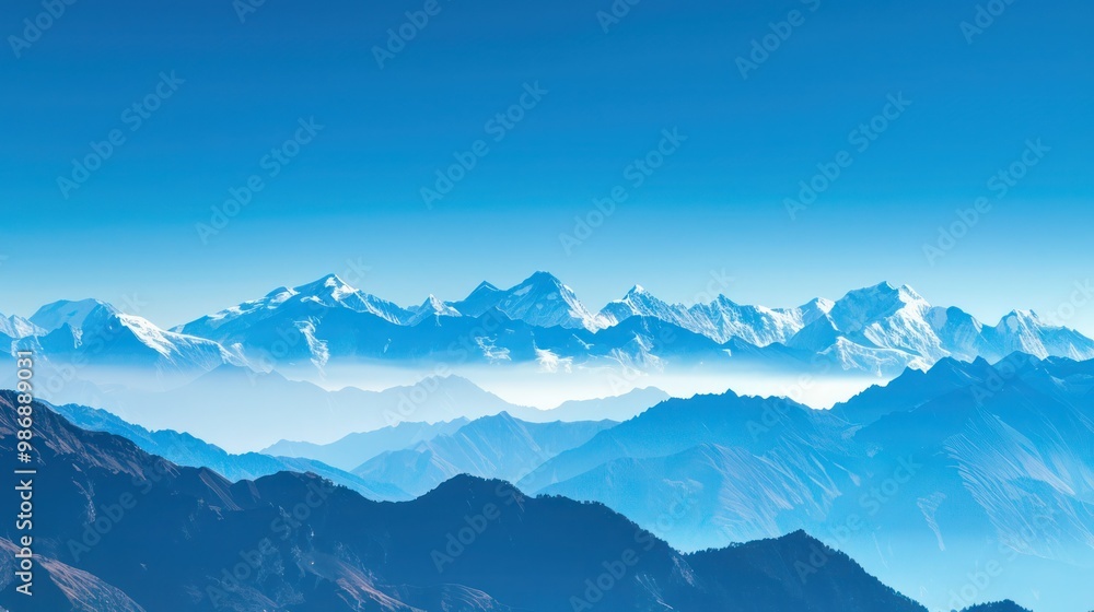 A panoramic view of snow-capped mountain peaks against a clear blue sky. A panoramic view of snow-capped mountain peaks against a clear blue sky.