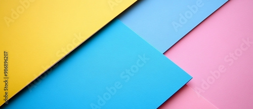 Vibrant colored paper sheets in yellow, blue, and pink, ideal for creative projects, presentations, and artistic backgrounds.