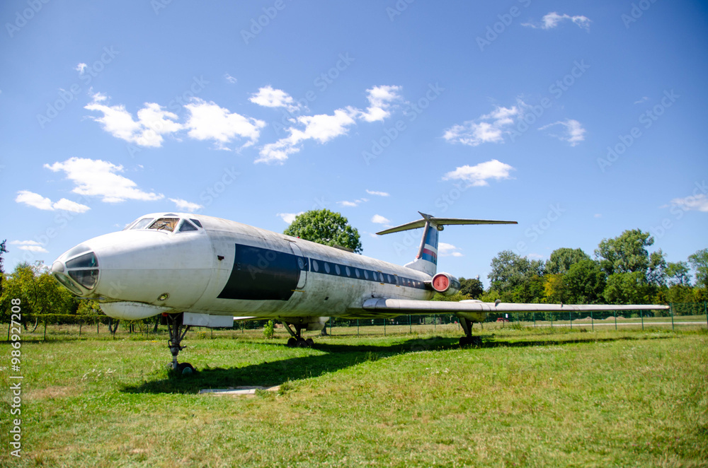 Samples of old military equipment. The engine and propeller of the cargo plane against blue cloudy sky. Separate parts of the fuselage, close-up. Old airplane in museum of aviation at Retro cars