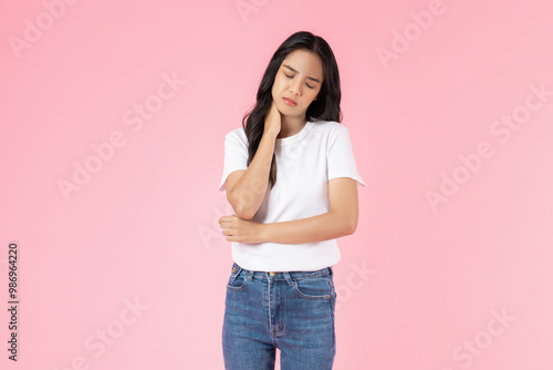 Unhealthy Asian woman touching body and pain in neck on pink background.