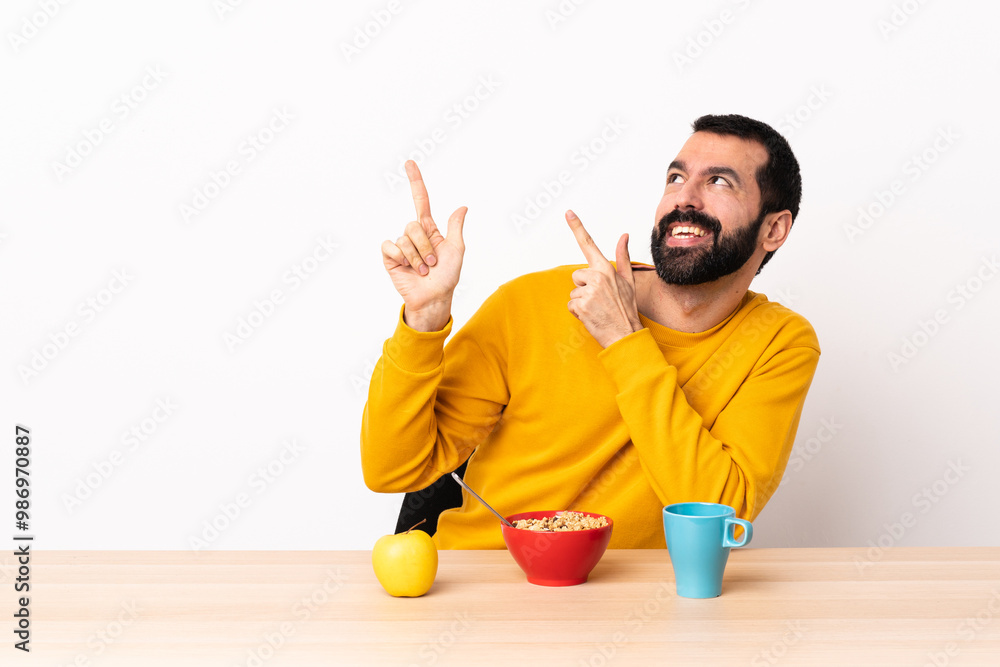 Caucasian man having breakfast in a table pointing with the index finger a great idea. Caucasian man having breakfast in a table pointing with the index finger a great idea.