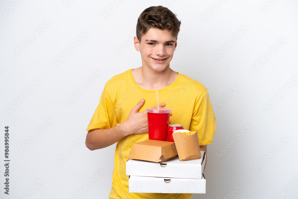 Teenager Russian man holding fast food isolated on white background smiling a lot Teenager Russian man holding fast food isolated on white background smiling a lot