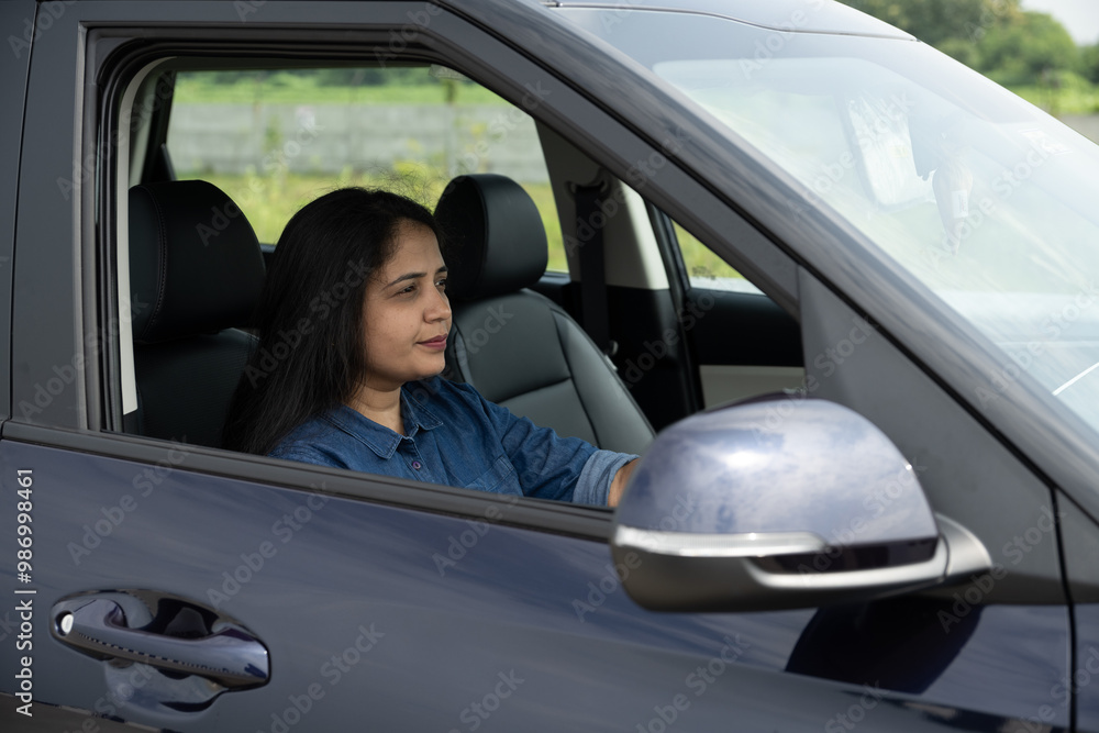 Happy indian woman driving a car in the city. Portrait of smiling female with safety belt traveling in her auto. Happy indian woman driving a car in the city. Portrait of smiling female with safety belt traveling in her auto.