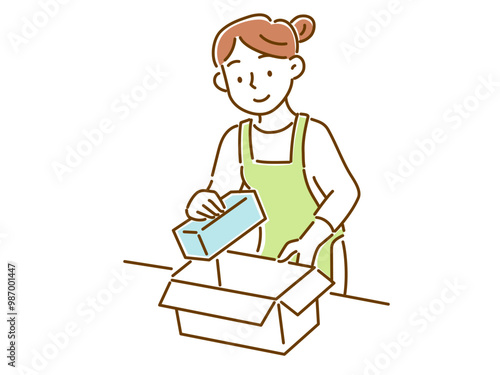 段ボールに荷物をいれるエプロン姿の若い女性