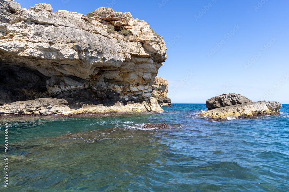 View from the water of picturesque coastline with cliffs and caves by Adriatic Sea, Polignano a Mare, Italy, Apulia