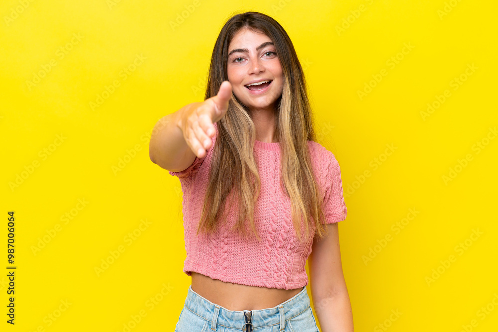 Young caucasian woman isolated on yellow background shaking hands for closing a good deal Young caucasian woman isolated on yellow background shaking hands for closing a good deal