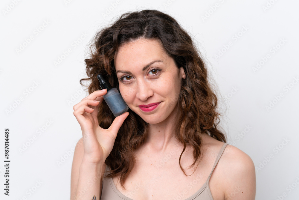 Young caucasian woman isolated on white background holding a serum. Close up portrait Young caucasian woman isolated on white background holding a serum. Close up portrait