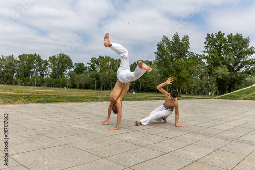 Bild auf Leinwand Teenager and middle aged man practicing capoeira , brazilian martial art