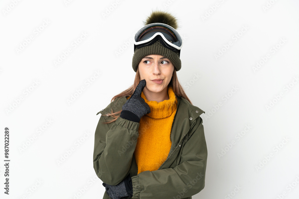 Skier caucasian woman with snowboarding glasses isolated on white background having doubts and thinking Skier caucasian woman with snowboarding glasses isolated on white background having doubts and thinking