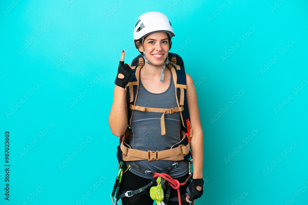 Young Italian rock-climber woman isolated on blue background pointing with the index finger a great idea Young Italian rock-climber woman isolated on blue background pointing with the index finger a great idea