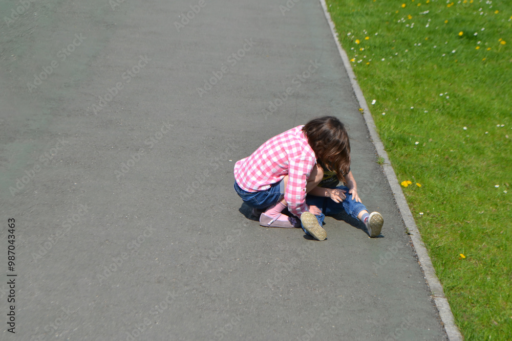 A sad crying toddler is sitting in the street by his mother's feet. High quality photo A sad crying toddler is sitting in the street by his mother's feet. High quality photo