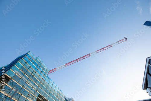 Crane reaching out over construction site with blue sky photo