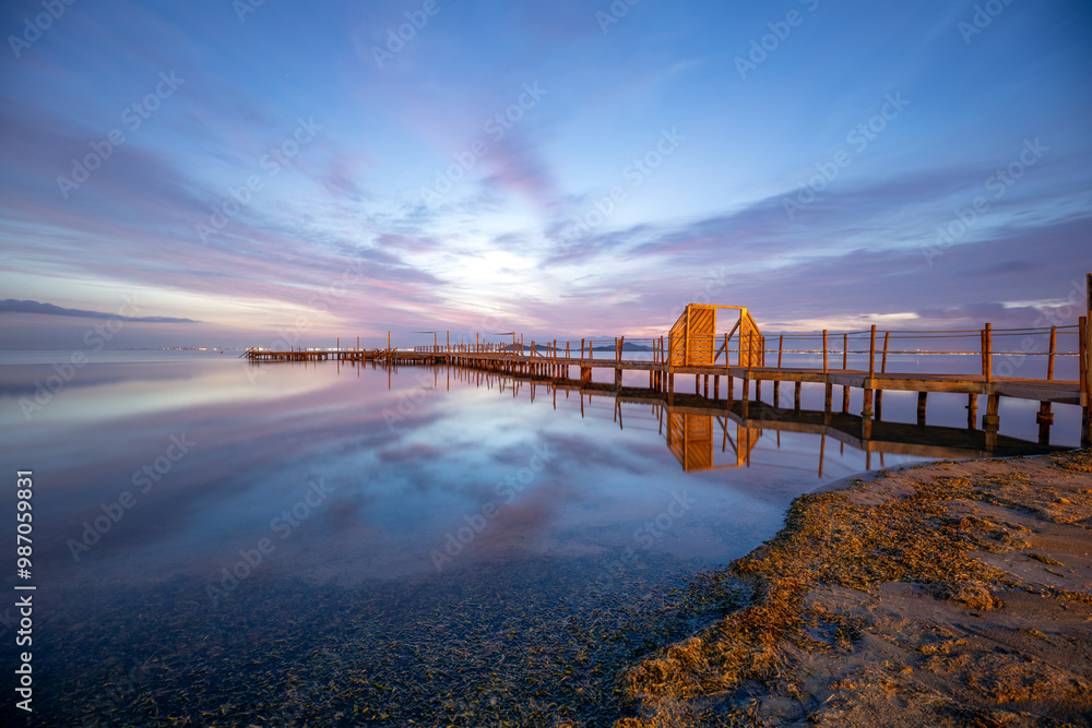 Colorful sunrise with the spa wooden walkway in the town of Los Urrutias, Cartagena, Mar Menor, Region of Murcia, Spain Colorful sunrise with the spa wooden walkway in the town of Los Urrutias, Cartagena, Mar Menor, Region of Murcia, Spain