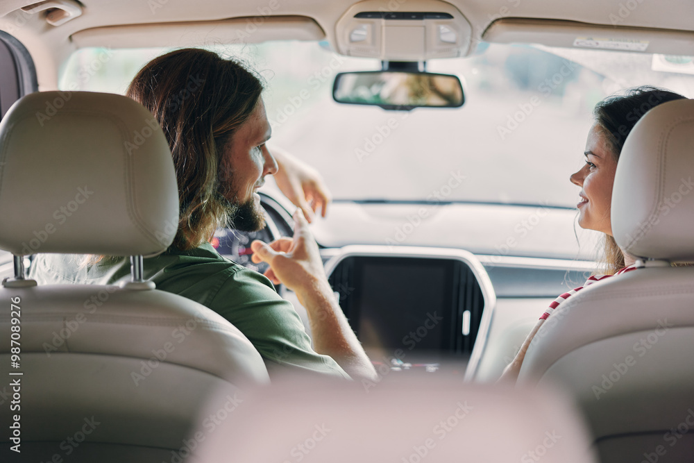 Young couple discussing in a car interior with soft sunlight filtering through the windows Young couple discussing in a car interior with soft sunlight filtering through the windows