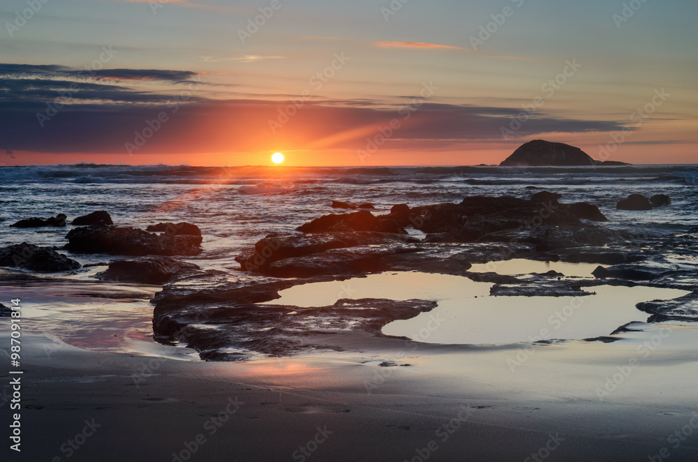 Φωτογραφία Muriwai beach at sunset. Oaia Island in the distance. Auckland.