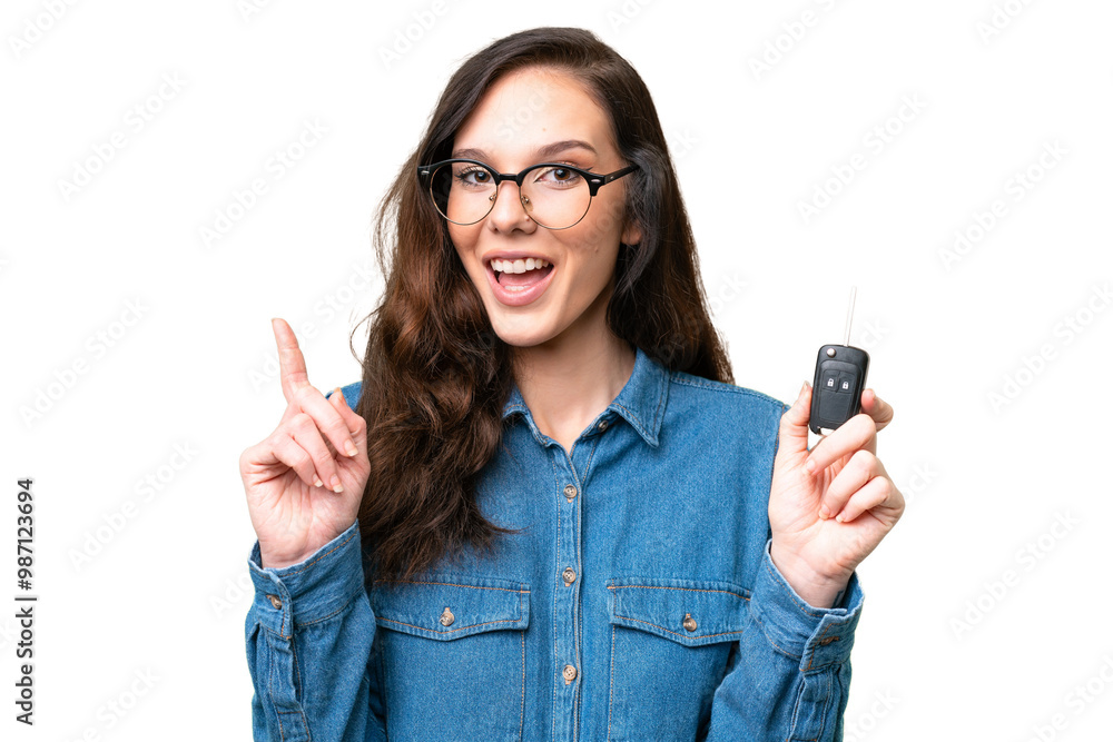 Young caucasian woman holding car keys over isolated background pointing up a great idea Young caucasian woman holding car keys over isolated background pointing up a great idea