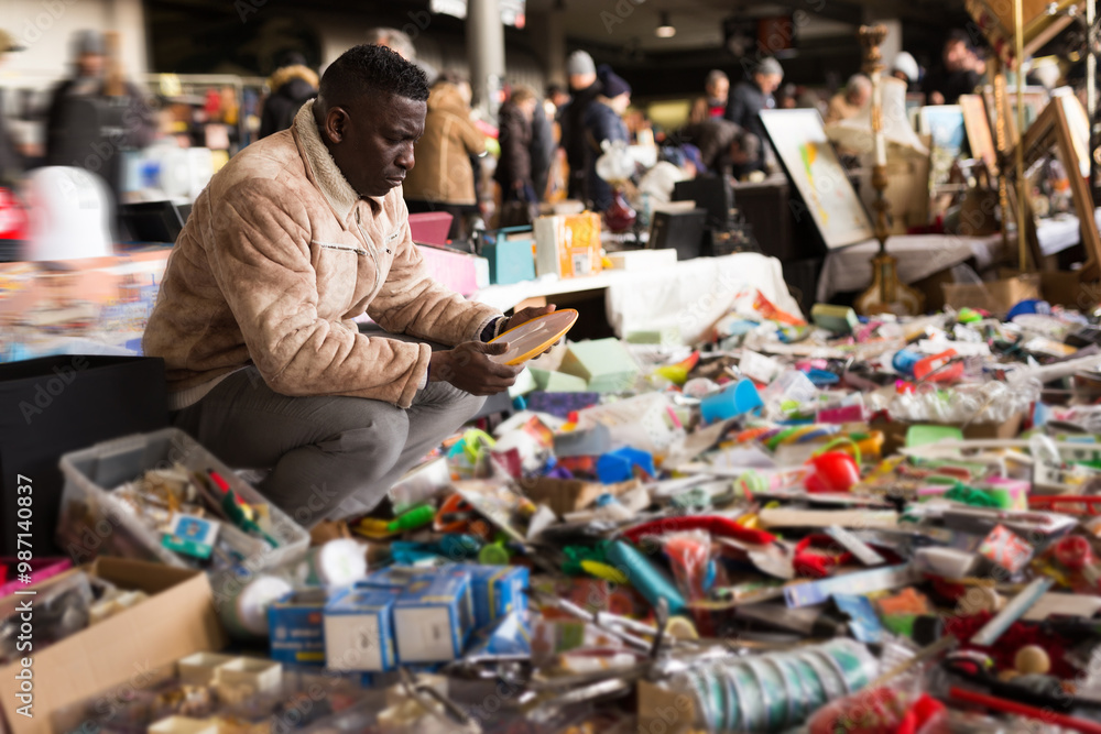 Man chooses antiques at a flea market Man chooses antiques at a flea market