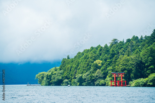 Obraz na płótnie Beautiful serene lake with lush green forest and torii gate w salonie