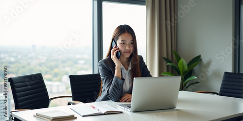 A  business woman is discussing a new strategy over the phone in a bright and productive office (with copy space).