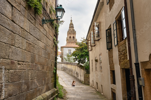 Tourist woman walking through the narrow streets of the historic center of Santiago de Compestela, Galicia.