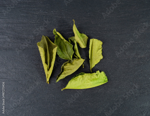 Thai lime dried leaves, makrut lime or Citrus hystrix leaf pile, kaffir lime dry sprouts, Southeast Asia spices photo