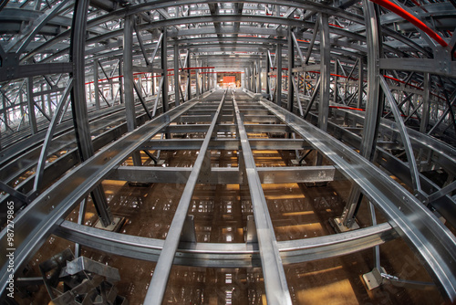Fish-eye view of steel galvanised framework clad rack structure of asrs warehouse with sprinkler system piping and reflections in rainwater pond