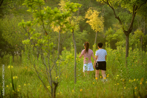 Luannan County, Hebei Province, China - July 11, 2024: Two women walk and exercise in the park grass in the morning photo