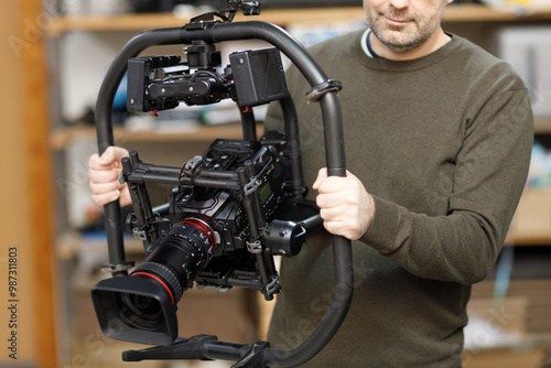 Obraz na płótnie Professional videographer holding camera on gimbal rig steadycam to make video without shaking w salonie